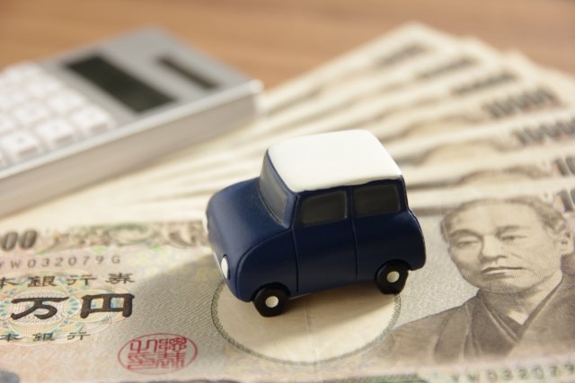 電卓と紙幣とミニカー。諸費用を含む支払総額のイメージ